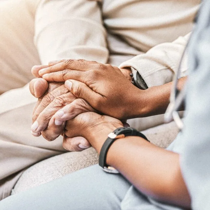 Dr holding hand of old man