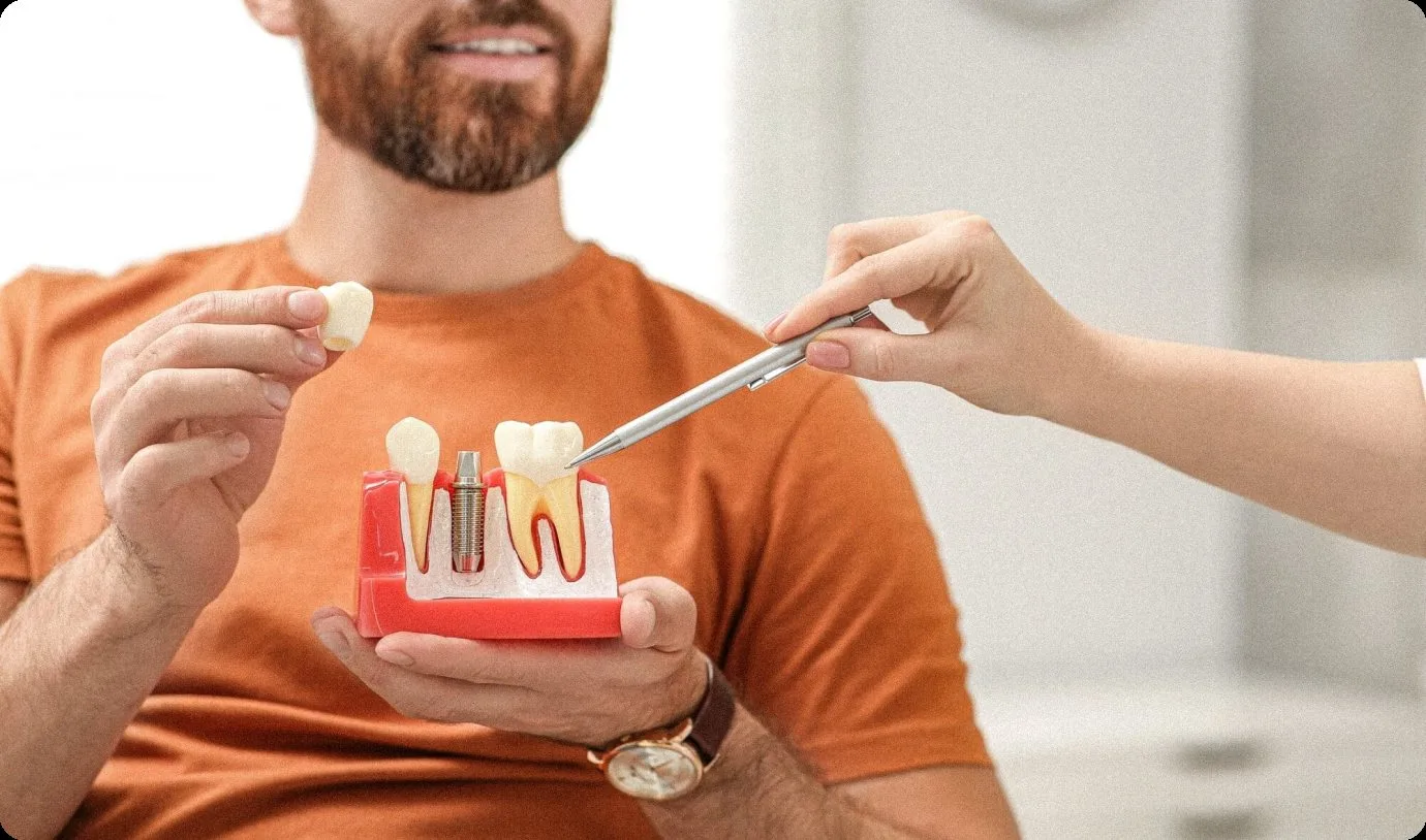 Dentist explaining a dental implant on a model