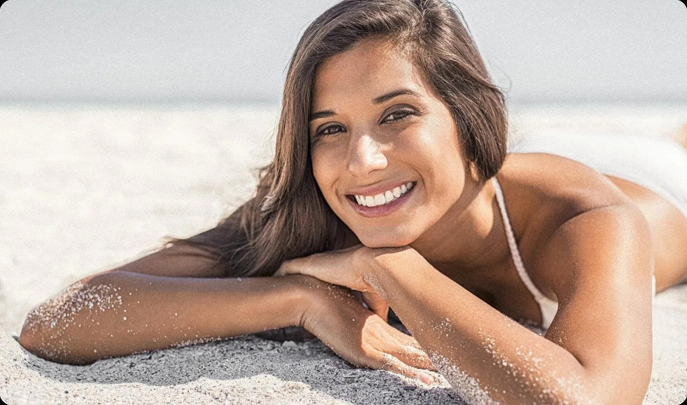 Smiling woman on the beach after root canal treatment